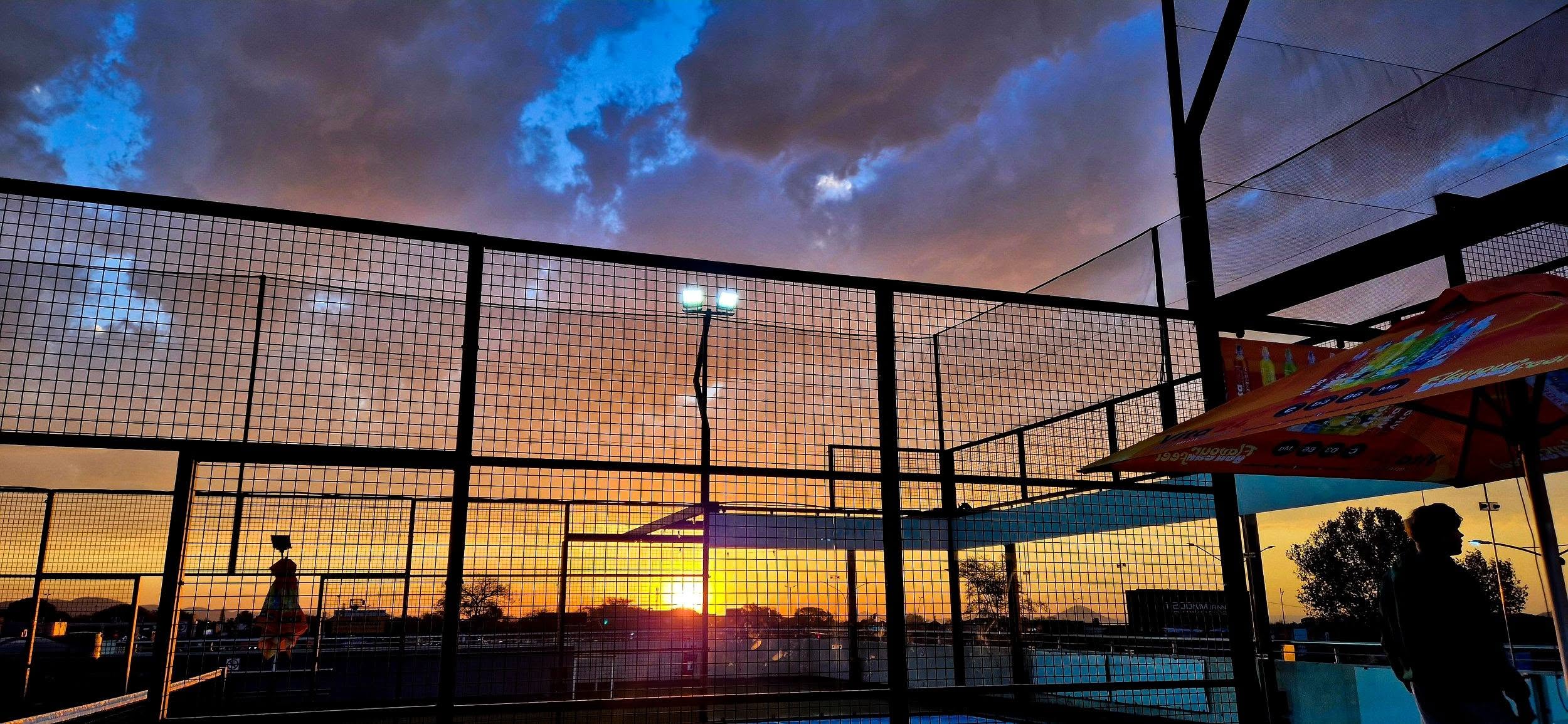 Sunset over the glass padel courts at SKYe Padel in Montana